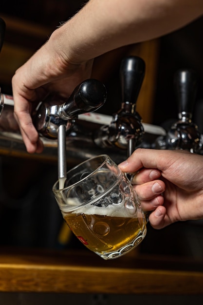 bartender pours beer into a glass at the restaurant bar