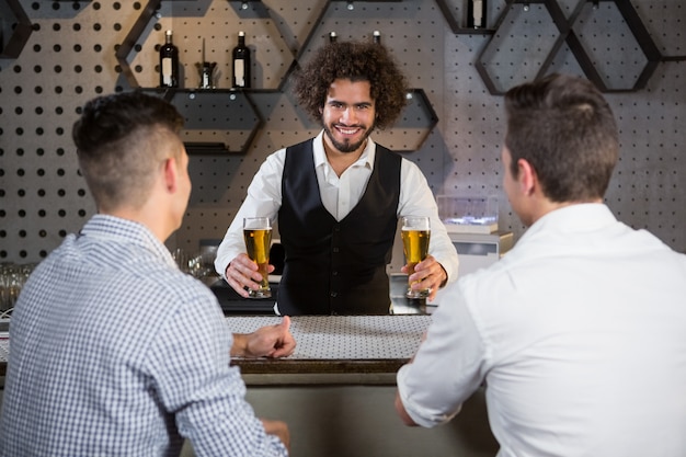 Photo bartender serving beer to customers