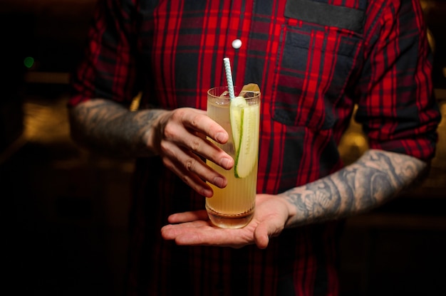 Bartender serving a glass of a Lynchburg lemonade cocktail on the bar counter