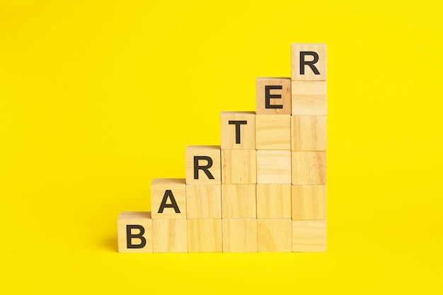 BARTER text on wooden cubes yellow background