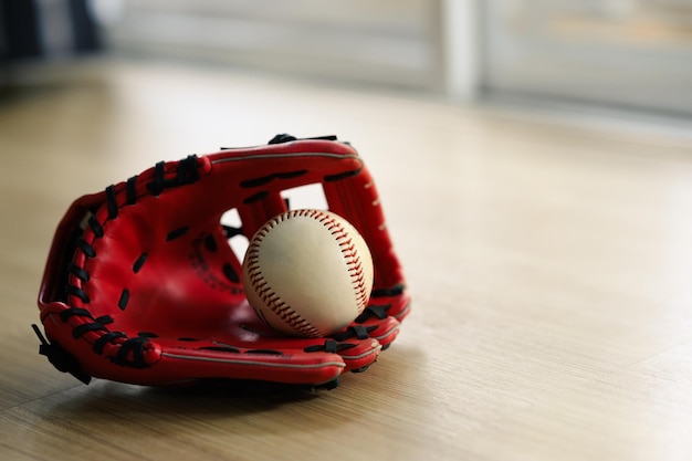 Baseball ball in a glove on the wooden table with copy space Sport concept