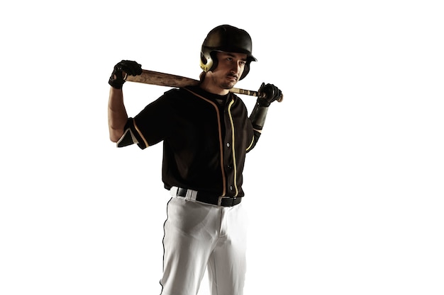 Baseball player, pitcher in a black uniform practicing and training isolated on a white wall. Young professional sportsman in action and motion. Healthy lifestyle, sport, movement concept.