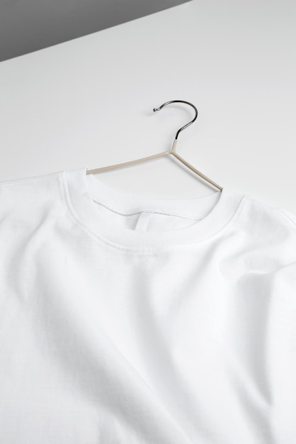 Basic white tshirt and hanger on table Mock up for branding tshirt Copy space