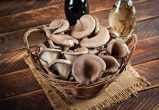 Basket of delicious organic oyster mushrooms on wooden background