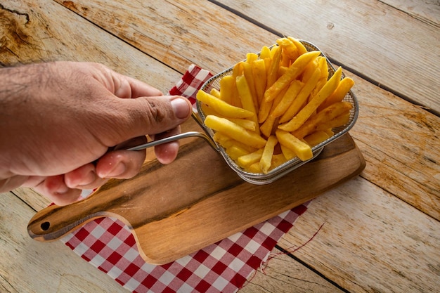 Basket full of french fries on rustic wooden table