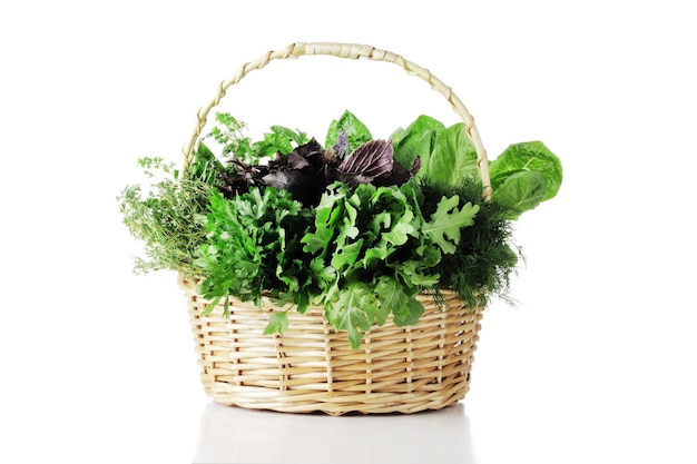 Basket full of fresh herbs isolated on white background