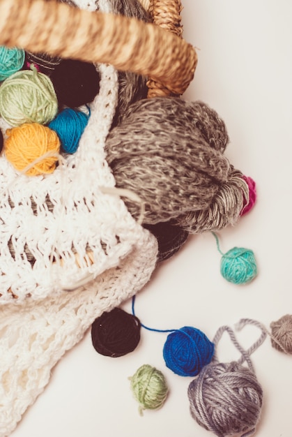 Basket with balls of yarn on white background