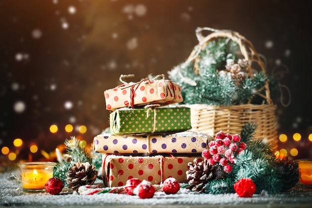 Basket with Christmas toys and Christmas gifts on a wooden background