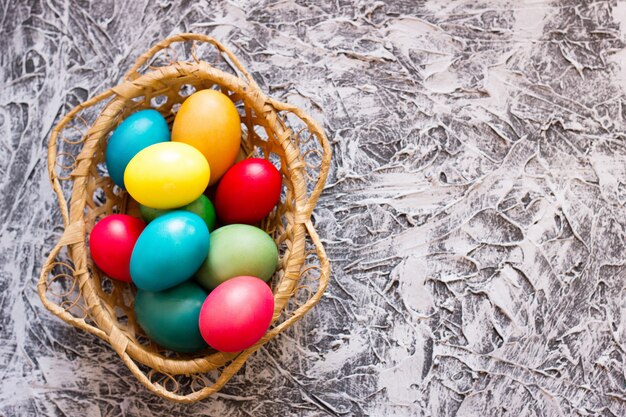 Basket with Easter eggs on the background of a concrete background, concept for the holiday of Easter, spring holiday