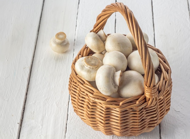 Basket with mushrooms on a white background of boards close-up.