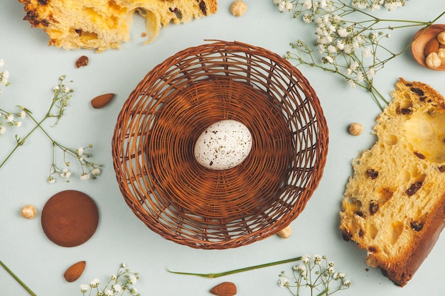 A basket with a nest in it and a bunch of muffins on the side.