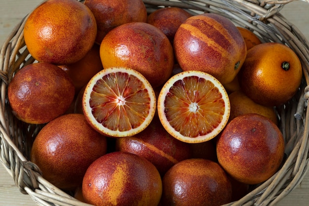 Basket with whole and halved blood oranges close up