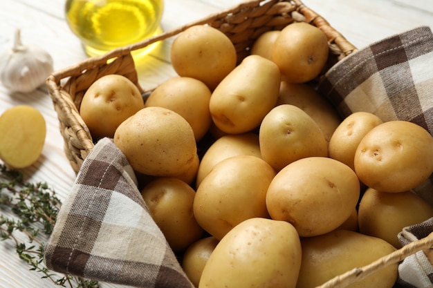 Basket with young potatoes on wooden surface