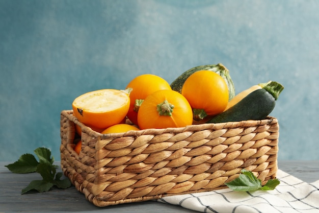 Basket with zucchini on napkin on wooden table