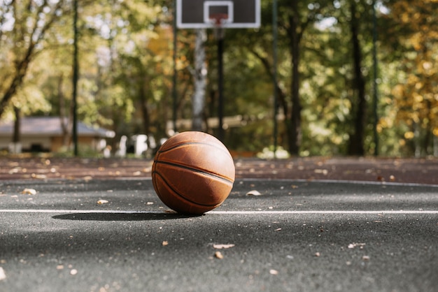 Basketball ball on the sports field. Healthy lifestyle and sport concepts. Court with hoop on the background. Sport equipment.