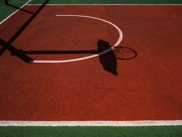 Basketball court. Bright sun and dense shadows on basketball court