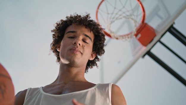 Basketball guy taking rest outdoors portrait young man tossing ball at stadium