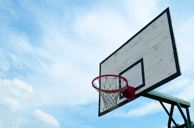 Basketball hoop on board against blue sky outdoor in courtyard