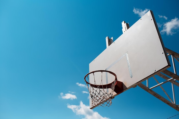 Basketball hoop in sunny day in background of blue sky Copy space