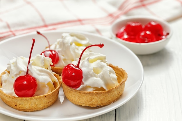 Baskets of pastries with cherry and cream tartlets with soft cream and cherries