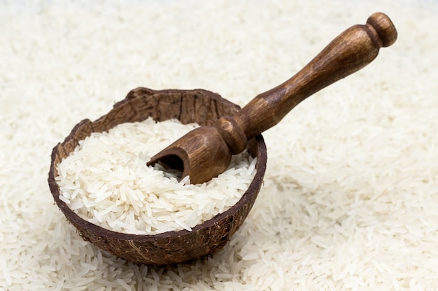 Basmati rice in coconut shell with wooden scoop. Close up. Top view