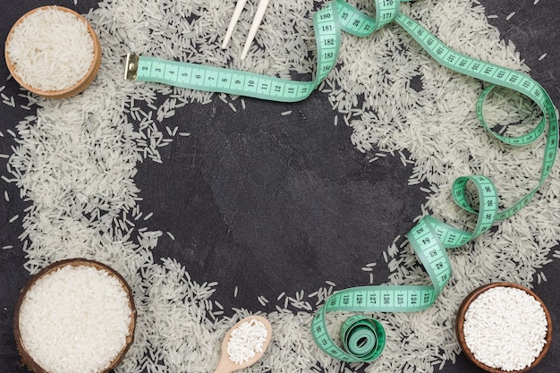 Basmati rice is scattered on table. Round rice in wooden bowl