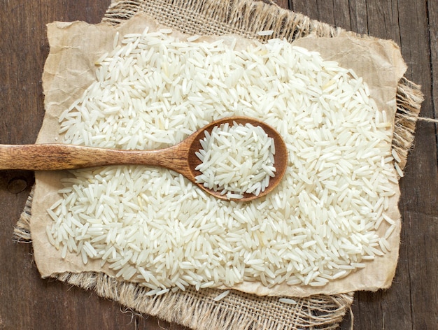 Basmati rice with a spoon on brown wooden table