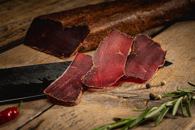 Basturma dried meat sliced on a wooden table