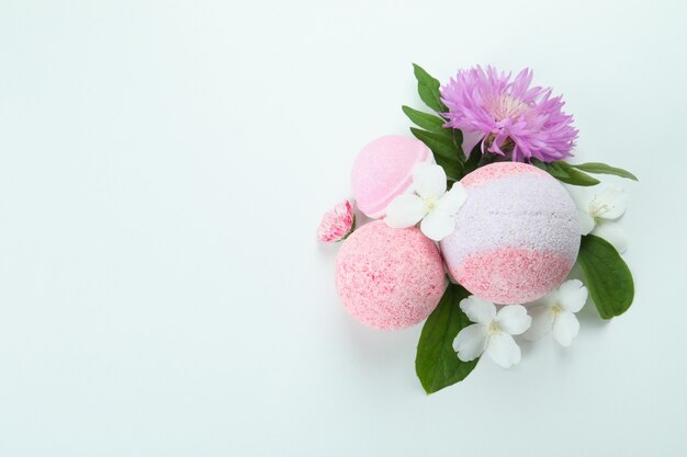 Bath balls and flowers on white background, space for text