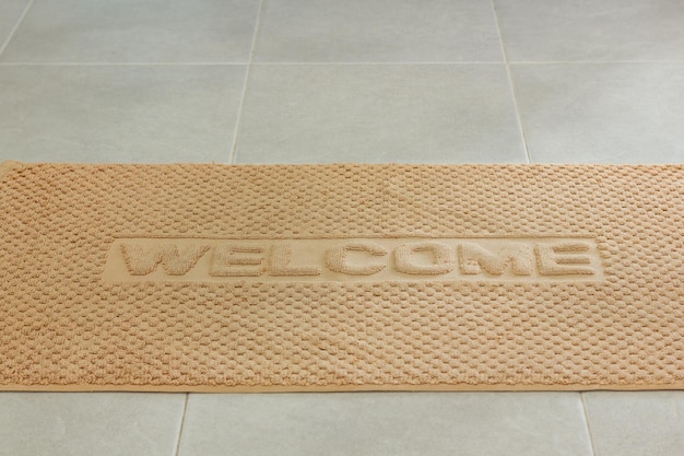 Bath towel with welcome sign on the bathroom floor. Hotel accommodation, resort guest room concepts