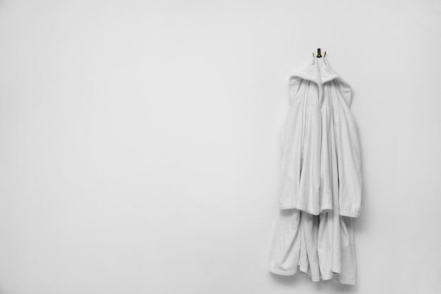 Bathrobes hanging on white wall