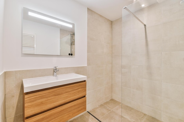 Bathroom interior finished with beige tiles with a sink under the mirror in a cozy house