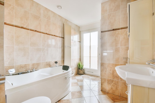 Bathroom interior finished with marble tiles with bathtub and sink in a modern house