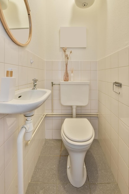 Bathroom interior in white tones with a toilet and ceramic sink under the mirror