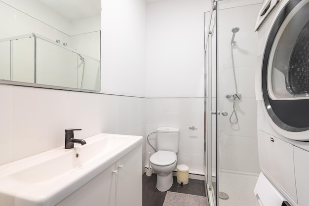 Bathroom with white walls and black marble floor tiles toilet bowl and bucket for used toilet paper