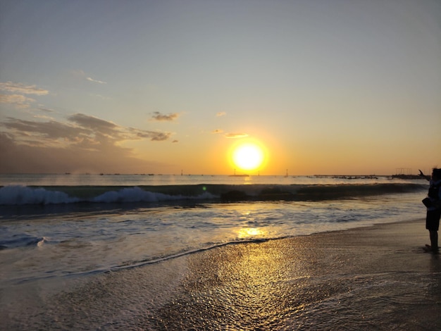 The bauty of sunset on the beach with the ship sailing