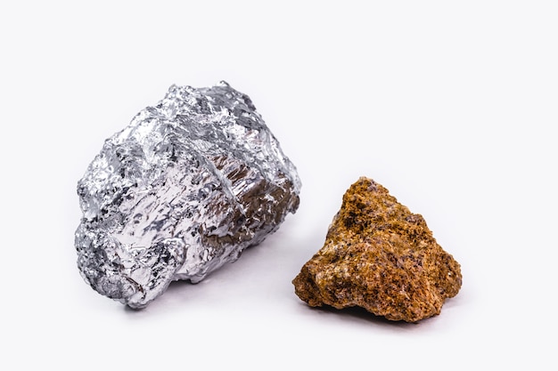 Bauxite ore and aluminum stone together on isolated white background, industrial use ore.