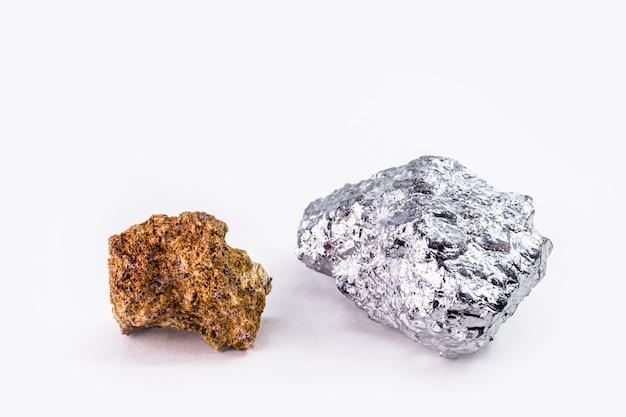 Bauxite ore and aluminum stone together on isolated white surface, industrial use ore.