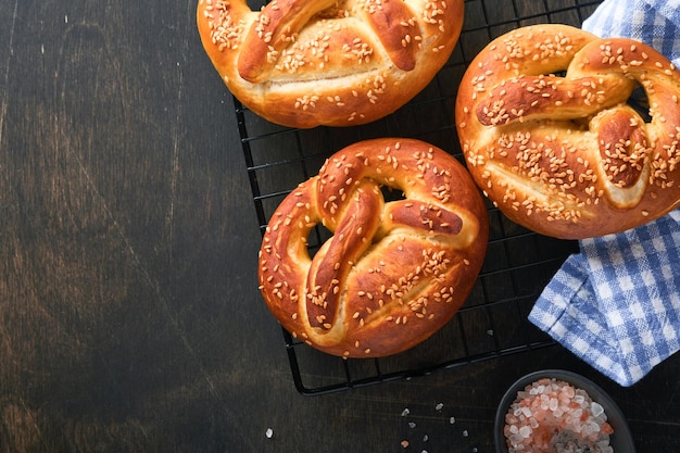 Bavarian pretzels and glass of lager beer Oktoberfest food menu traditional salted pretzels over old dark wooden background Top view with space for text Oktoberfest theme