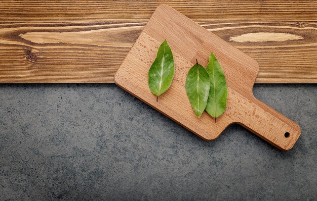 The bay leaves on cutting board set up on shabby wooden