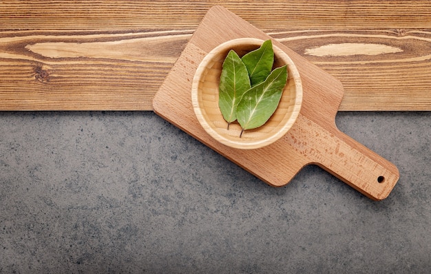 The bay leaves on cutting board set up on shabby wooden