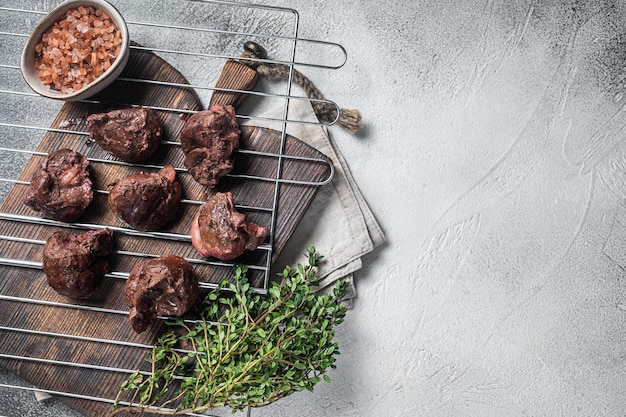 BBQ Grilled lamb mutton kidney offal meat on grill White background Top view Copy space