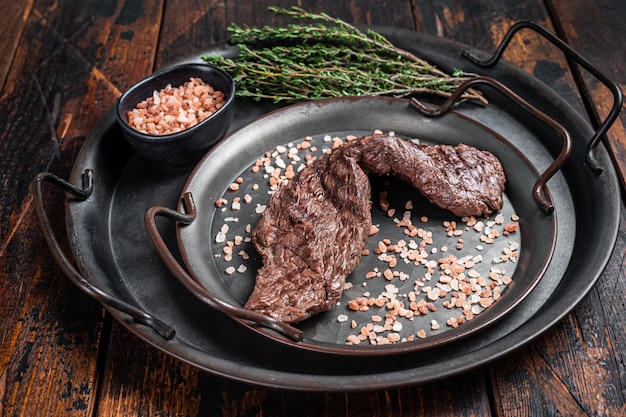 BBQ Grilled Machete or skirt beef meat steak in steel tray Wooden background Top view