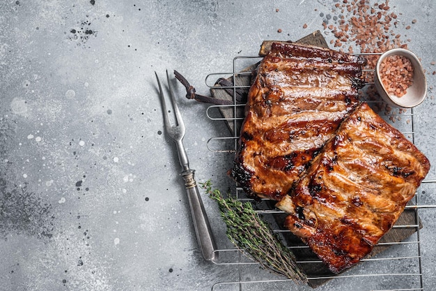 BBQ grilled pork ribs in Barbecue sauce on a grill Gray background Top view Copy space