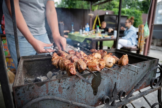 BBQ picnic with kebabs and meat on an open fire on a summer day in the backyard of a private house