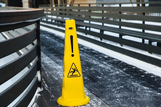 Be aware of slippery road Slippery yellow surface sign Wet floor sign Icing concept Selective focus Slippery slope Watch your step please