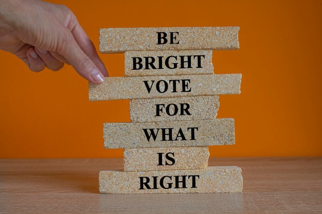 Be bright vote for what is right Words on brick blocks Beautiful orange background Wooden table