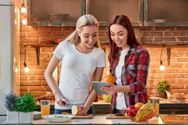 Be smart eat smart young female friends preparing together healthy meal in modern kitchen cozy