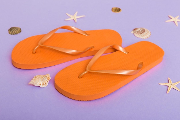 Beach accessories Flip flops and starfish on colored background Top view Mock up with copy space