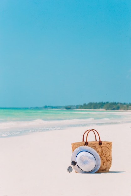 Beach accessories - straw bag, hat and unglasses on the beach